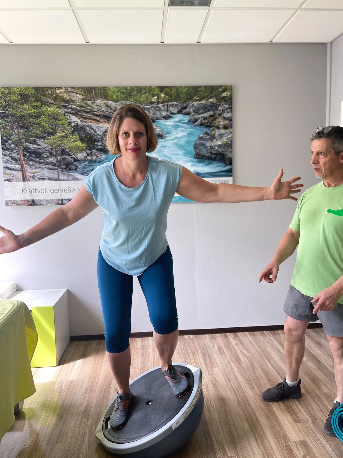 Fitnesstrainer und Berater - Wolfgang Bzdok trainiert eine Frau auf einem Physioball